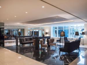 a lobby with a bar with chairs and tables at Sofitel Athens Airport in Athens