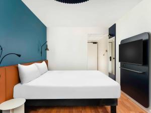 1 Schlafzimmer mit einem weißen Bett und einem TV in der Unterkunft Ibis Budapest Centrum in Budapest