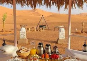 a table with food on it in the desert at Shiny luxury camp in Merzouga