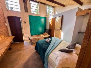 a bedroom with a large bed in a room with windows at Pousada Vale das Primaveras in Três Corações