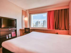 um quarto de hotel com uma cama e uma janela em ibis Sao Paulo Congonhas em São Paulo
