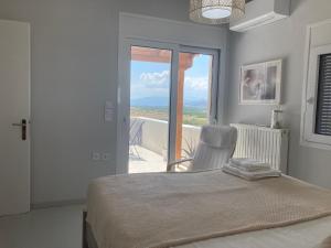 a bedroom with a bed and a view of a balcony at Enchanting Mycenae - Your Greek holiday retreat in Argos