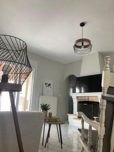 ein Wohnzimmer mit einem Tisch und einem Kamin in der Unterkunft Enchanting Mycenae - Your Greek holiday retreat in Argos