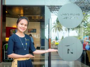 kobieta stojąca przed szklanymi drzwiami w obiekcie Novotel Nha Trang w mieście Nha Trang