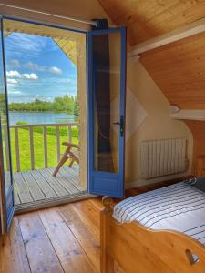 een slaapkamer met een deur naar een balkon bij Gite du lac du Palentin Ardres in Ardres