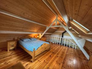 een slaapkamer met een bed op een houten zolder bij Gite du lac du Palentin Ardres in Ardres