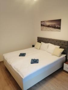 1 dormitorio con 1 cama blanca y 2 toallas azules en Karkonoskie Cztery Kąty, en Karpacz