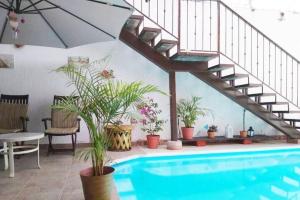 una piscina con una escalera junto a una casa en Depto Perla a 5 mins de playa con alberca y wifi, en Cabo San Lucas