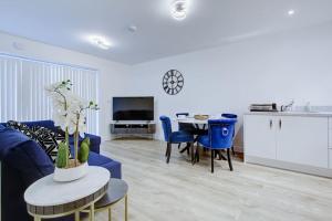 a living room with a blue couch and a table at Brand New apartment next to Lakeside Shopping mall, Essex in West Thurrock