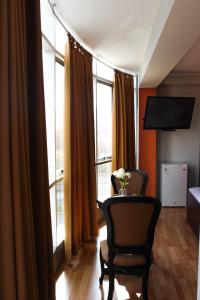 a room with two chairs and a table and windows at Hotel PLATINIUM in Tacna