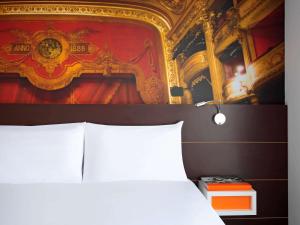 ibis Styles Montpellier Centre Comedie في مونبلييه: غرفة نوم بسرير ودهان على الحائط