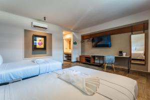 Habitación de hotel con 2 camas y TV en Hotel MID Project en Mérida