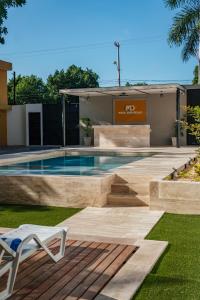 una piscina en un patio con una silla blanca en Hotel MID Project, en Mérida