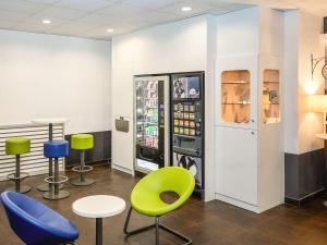 una tienda con sillas coloridas y una máquina de refrescos en Ibis Budget Lille Gares Vieux-Lille, en Lille