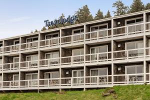 an apartment building with a sign on top of it at Travelodge by Wyndham Depoe Bay in Depoe Bay