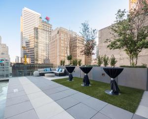 - un toit-terrasse avec un canapé et une pelouse dans l'établissement Hilton Garden Inn Downtown Dallas, à Dallas