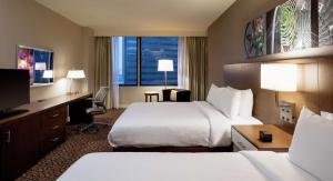 Habitación de hotel con 2 camas, escritorio y TV. en Hilton Garden Inn Downtown Dallas en Dallas