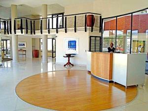 Ein Mann, der an einem Schreibtisch in einem großen Raum sitzt in der Unterkunft Executive apartment - Sandton in Johannesburg + 14 Fotos