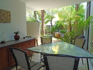 einen Tisch und Stühle in einem Zimmer mit Terrasse in der Unterkunft Executive apartment - Sandton in Johannesburg