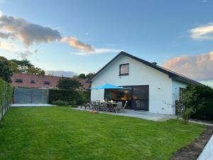 Biały dom z dziedzińcem ze stołami i krzesłami w obiekcie Boldermountain Guesthouse w mieście Heusden-Zolder