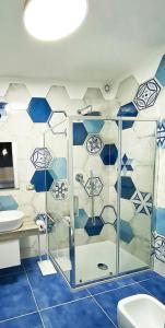 ein Badezimmer mit blauen und weißen Wänden und einer Dusche in der Unterkunft Relais Galatea in Montecorvino Pugliano