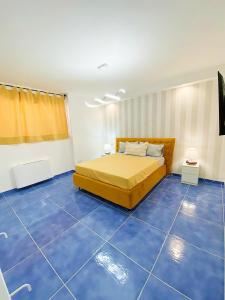 Schlafzimmer mit einem Bett und blauen Böden in der Unterkunft Relais Galatea in Montecorvino Pugliano