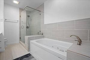 a white bathroom with a tub and a shower at Small Town, Big House - Sleeps 8! in Taylor +14 photos