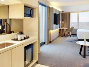 a kitchen and living room in a hotel room at Novotel Suites Yogyakarta Malioboro in Yogyakarta