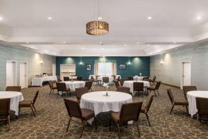 a dining room with white tables and chairs at Wingate by Wyndham Savannah I-95 North in Port Wentworth