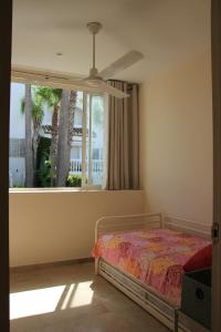 una camera con letto e finestra di Chalet adosado en urbanización con piscina a Estepona