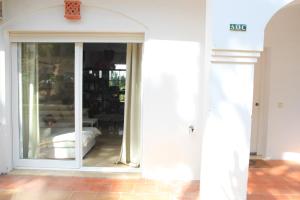 una entrada a una habitación con una puerta corredera de cristal en Chalet adosado en urbanización con piscina, en Estepona