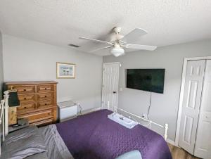 una camera con letto e ventilatore a soffitto di 2 private rooms in a quiet neighborhood can book up to 4 people a Orlando