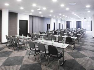 ein großes Zimmer mit Tischen und Stühlen in der Unterkunft Mövenpick Hotel Stuttgart Airport in Stuttgart