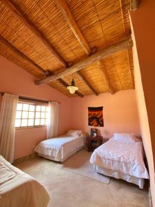 - une chambre avec deux lits et un plafond en bois dans l'établissement hosteria castillos de huichaira, à Maimará