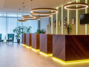 un hall de bureau avec une réception et des lumières dans l'établissement Mövenpick Hotel Stuttgart Messe & Congress, à Stuttgart