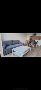 een woonkamer met een bank en een tafel bij T2 Echappée Marine in Balaruc-les-Bains