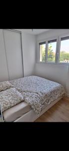 een bed in een witte kamer met 2 ramen bij T2 Echappée Marine in Balaruc-les-Bains