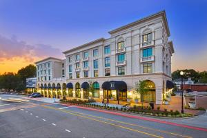 a large white building on a city street at dusk at The Hamilton Alpharetta, Curio Collection By Hilton in Alpharetta