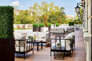 a row of tables and chairs on a patio at The Hamilton Alpharetta, Curio Collection By Hilton in Alpharetta