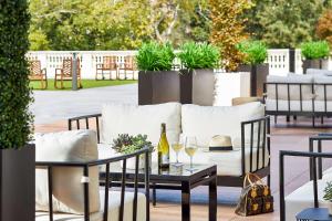 a patio with a couch and a table with wine glasses at The Hamilton Alpharetta, Curio Collection By Hilton in Alpharetta
