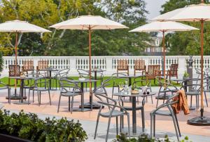 a group of tables and chairs with umbrellas at The Hamilton Alpharetta, Curio Collection By Hilton in Alpharetta