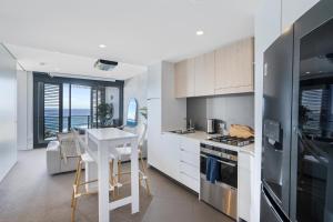 a kitchen with a table and a kitchen with a view of the ocean at 603 Newcastle Beachfront Apartment in Newcastle