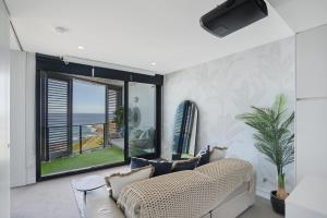 a living room with a couch and a large window at 603 Newcastle Beachfront Apartment in Newcastle