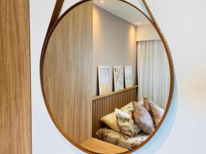 a mirror in a room with a bed with pillows at FLAT EXCELSIOR- PRÓXIMO SHOPPING RIOMAR in Recife