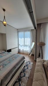 um quarto com uma cama e uma grande janela em TOYA Next Residence em Istambul