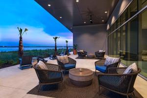 eine Terrasse mit Stühlen und einem Tisch mit Aussicht in der Unterkunft Hyatt Regency Baytown-Houston in Baytown