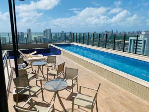 a balcony with chairs and a swimming pool on a building at FLAT EXCELSIOR- PRÓXIMO SHOPPING RIOMAR in Recife