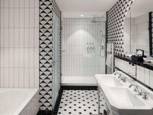 a white bathroom with a tub and a sink at The 1932 Hotel & Spa Cap d'Antibes - MGallery Collection in Juan-les-Pins