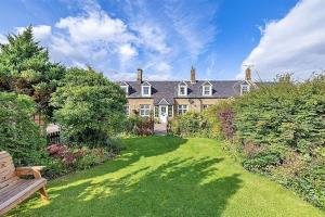 a large house with a bench in a yard at 2 Swinton Mill Farm Cottage in Swinton