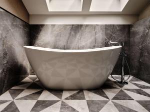 a large bath tub in a bathroom with a tile floor at The Crown Krakow Center - Handwritten Collection in Kraków